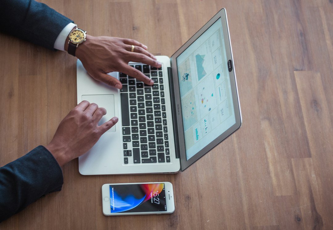 Person using a MacBook to compare free and paid AI tools