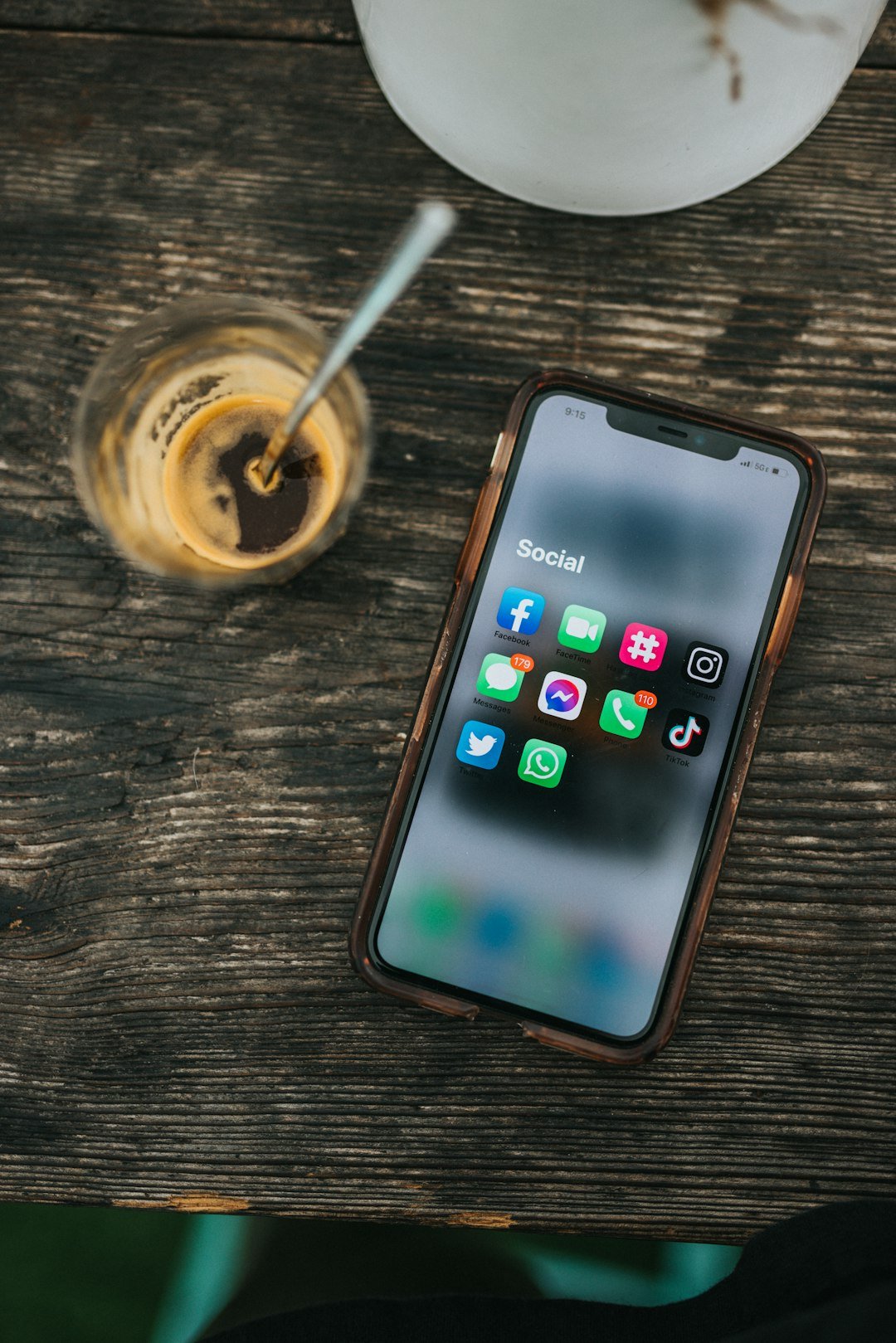 Smartphone showing social media apps beside a coffee while following developer news