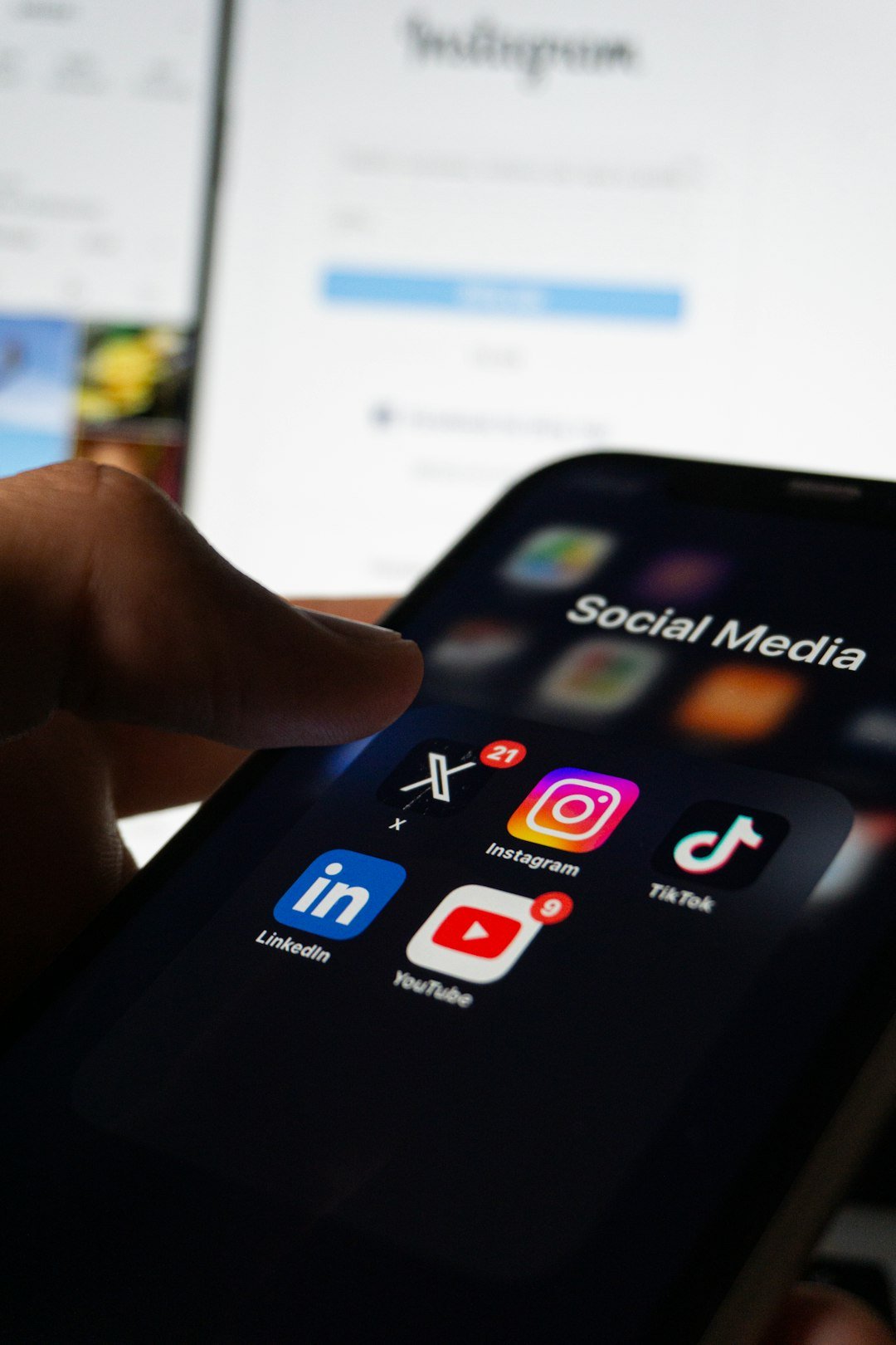 Social media news programgeeks topic shown with a person holding a smartphone with social media on the screen
