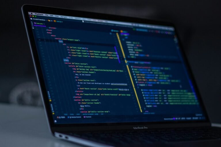 Software programgeeks guide shown with a MacBook displaying programming code